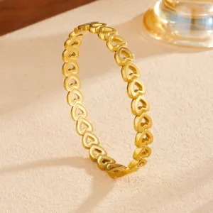 Close-up detail of the elegant hollow heart gold stainless steel fashion bangle bracelet.