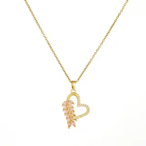 Detail shot of the golden heart pendant necklace featuring sparkling pink marquise and clear stones.