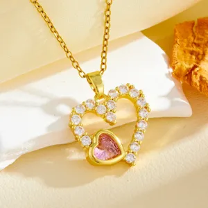 Close-up of gold double heart necklace with sparkling white and pink cubic zirconia.
