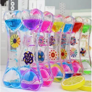 Detail shot of colorful liquid motion oil hourglass with spinning pinwheel, creative desktop toy.
