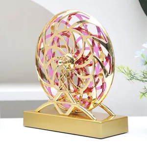 Nahaufnahme des kinetischen Perpetuum-Mobile-Schreibtischspielzeugs mit Gold- und Pink-Ringen.