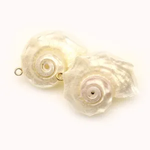 Gedetailleerde opname van natuurlijke schelp spiraalhangers met kleine metalen ringetjes.