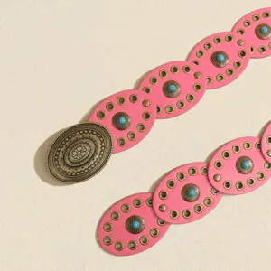 Pink oval round-piece leather belt with vintage bronze buckle and turquoise floral metal studs.