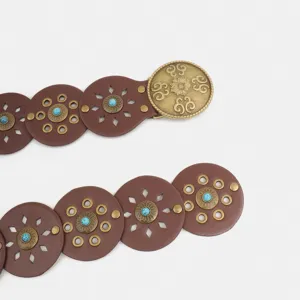 Western style vintage round disk spliced belt detail showing carved buckle and turquoise stone.