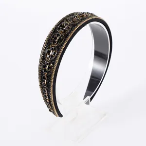 Detailed close-up of a sparkling black Baroque crystal headband with exquisite gold chain trim.