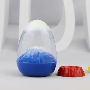 Liquid volcano eruption ornament detail, clear egg capsule with blue mountain and glitter.