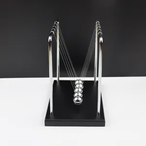 Detailopname van metalen Newton's wieg balans ballen met houten basis voor bureau.