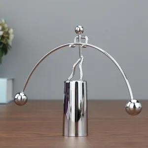 Detailopname van het zilverkleurige metalen balancerende mannetje als bureau ornament.