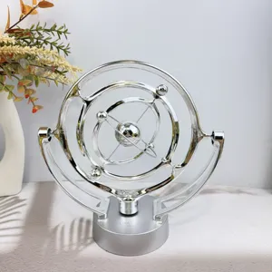 Close up of silver celestial orbit perpetual motion machine, creative desk decor toy.