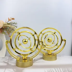 Detail shot of golden celestial kinetic art desk toy, creative perpetual motion decor piece.