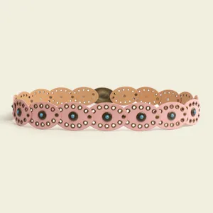 Close up of bohemian turquoise inlaid oval leather belt detail showing unique metal grommets.