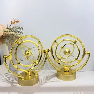 Golden celestial kinetic art desk toy detail showing intricate rotating rings and metal spheres.