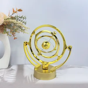 Golden kinetic art celestial perpetual motion machine desktop ornament for home office decor.