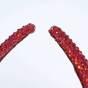 Close-up detail of a stunning red rhinestone encrusted headband, sparkling handmade crystal hair hoop.