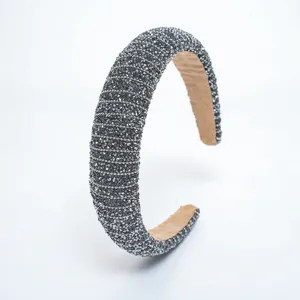 Vue détaillée de serre-tête rembourré en strass étincelant, accessoire de cheveux.