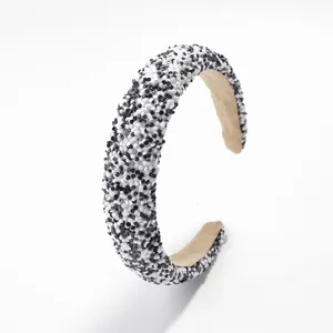 Primer plano de una diadema ancha elegante con cuentas en blanco y negro, textura fina.