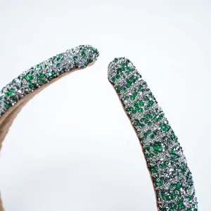 Gros plan d'un serre-tête éponge rembourré en strass vert scintillant, accessoire cheveux élégant.