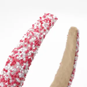 Detalle de diadema ancha decorada con diamantes de imitación rosados y blancos brillantes
