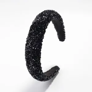 Primer plano detallado de la diadema acolchada negra brillante con diamantes de imitación.