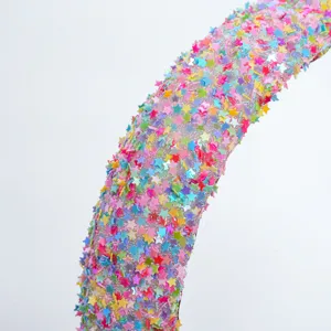 Close-up detail shot of colorful star sequin hair hoop, sparkling fairy headband design.