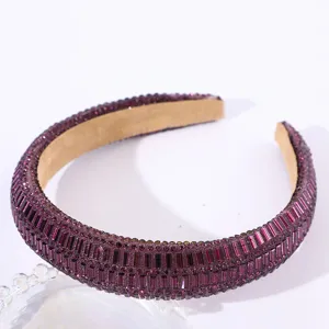 Detail shot of the purple rhinestone padded headband showing sparkling crystal texture and details.
