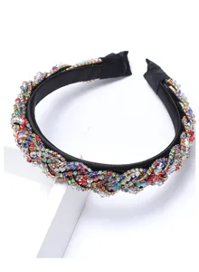 Gros plan détaillé d'un serre-tête tressé en cristal noir vintage, strass colorés brillants.