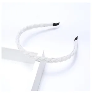 Gros plan détaillé du serre-tête tressé de perles blanches, accessoire en cristal.