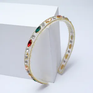 Gros plan d'un serre-tête baroque en strass avec cristaux colorés et bordure dorée.