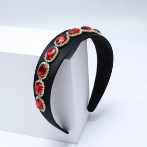 Primo piano dettagliato del cerchietto nero in stile barocco con gemme rosse e brillanti strass.