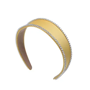 Serre-tête large élégant en strass avec finition satinée dorée, accessoire de mode.