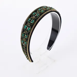 Exquisite Baroque rhinestone headband detail showcasing sparkling green crystals and gold trim.
