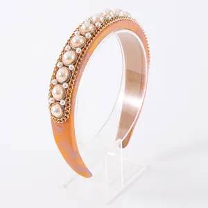 Serre-tête orange élégant incrusté de perles avec chaîne dorée, accessoire de mode chic.
