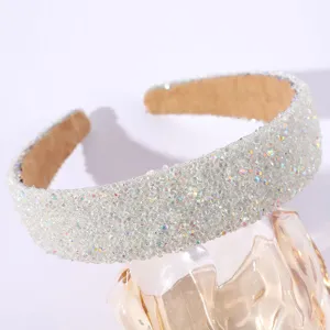 Serre-tête large en strass étincelant en détail montrant la texture brillante cristal.