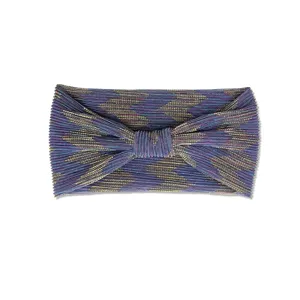 Dettaglio di una fascia per capelli elastica plissettata metallica viola con nodo a zigzag.