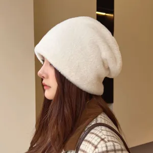 Soft white plush winter hat detail shot, showing cozy fabric texture and warm profile view.