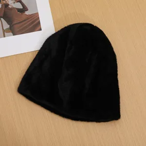Black plush furry winter warm beanie hat detail view, soft and cozy fabric texture.