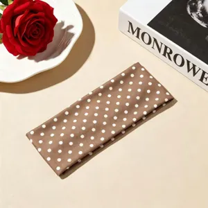Fascia per capelli a pois marroni in dettaglio, tessuto morbido, accessorio moda quotidiano ideale.