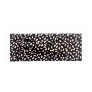 Vista dettagliata della fascia elastica nera con foglie rosa e design a nodi.