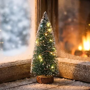 Detalle de mini árbol de Navidad verde flocado con luces LED cálidas en alféizar nevado.