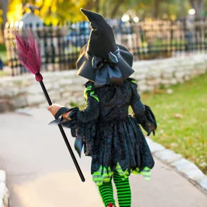 Bambino che tiene un supporto per scopa da strega di Halloween con setole in rete.