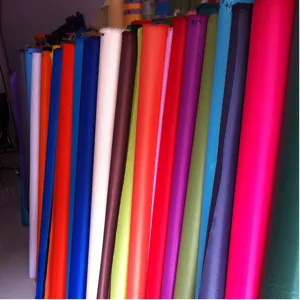 Fabric material detail shot showing various colorful polyester rolls for custom eco bags making.