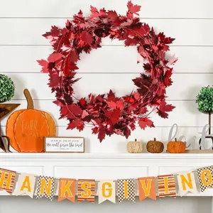 Red tinsel maple leaf wreath detail, shiny metallic Thanksgiving holiday hanging decoration.