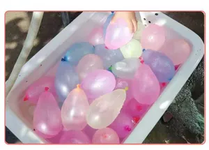 Detail shot of colorful water balloons filled in a white basin, perfect for outdoor summer games.