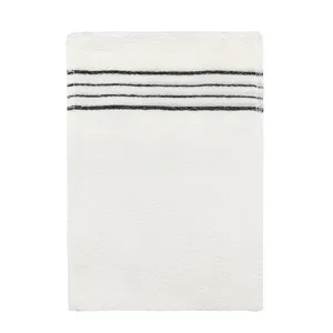 Vue de détail du gant de gommage de bain blanc avec des bandes noires pour le soin du corps.