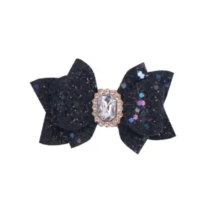 Black glitter bow accessory close-up featuring a sparkling rhinestone crystal center buckle detail.