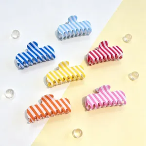 Close-up detailweergave van kleurrijke gestreepte haarclips met levendige snoepkleuren en design.