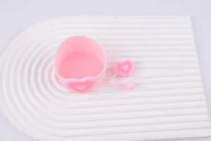 Pink silicone cup sleeve and cute heart straw cap set, detail shot showing texture and design.