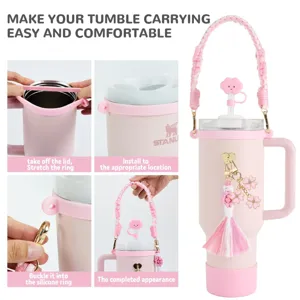 Rosa Stanley Becher Zubehör Set mit geflochtenem Gurt und Kleeblatt Schlüsselanhänger.