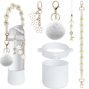 Ensemble de protection pour bouteille et sangle macrame decore de pompons mignons.