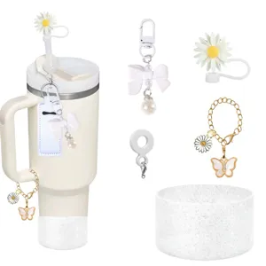 Tumbler accessories set featuring silicone straw covers, bow charms, and glitter cup boot.